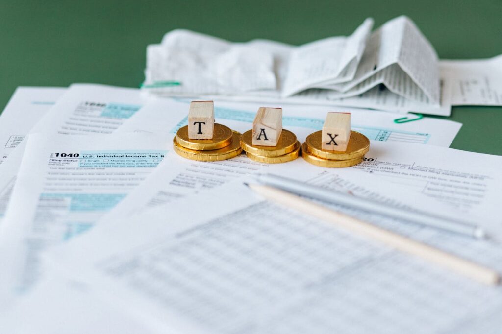Wood blocks that spell βTAXβ on a pile of tax forms