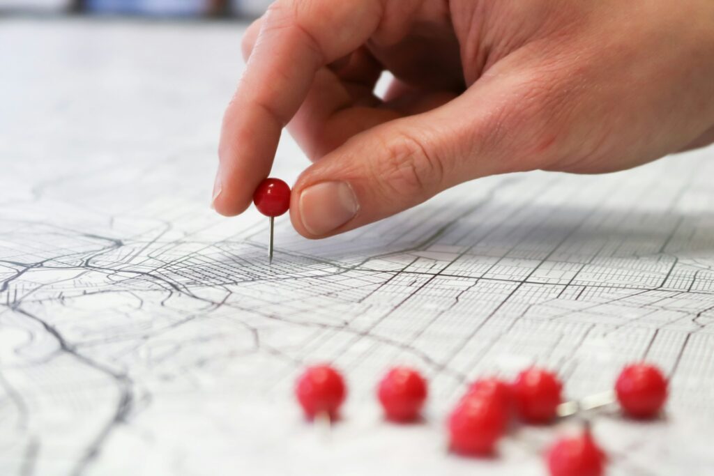 Person placing pins on a map.