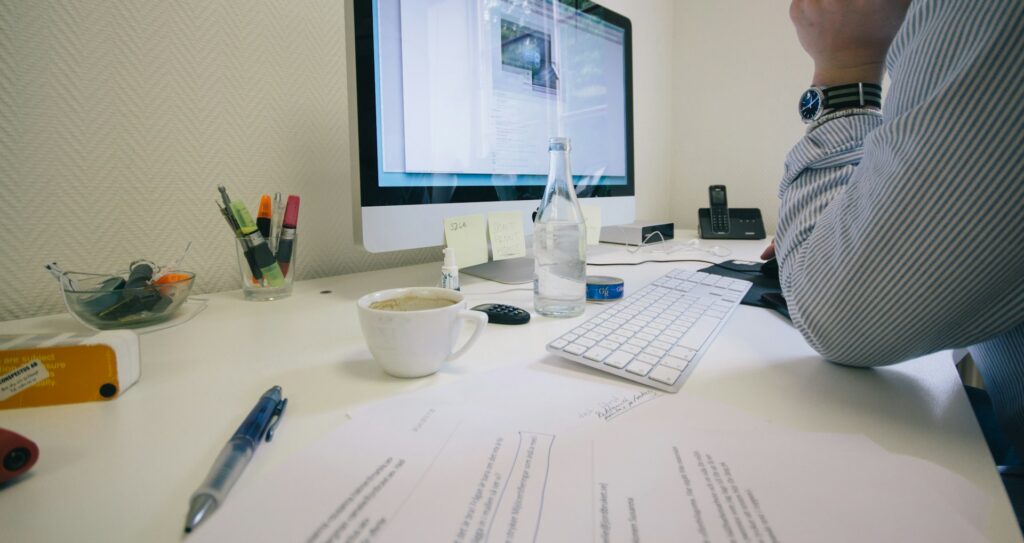 Person working at a cluttered office desk