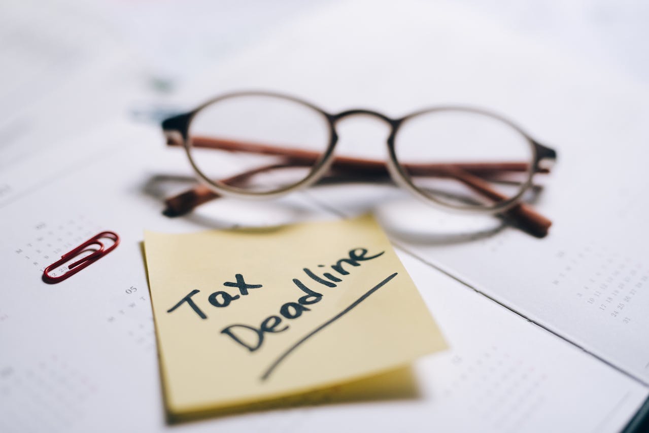 Glasses and a sticky note that says “tax deadline”