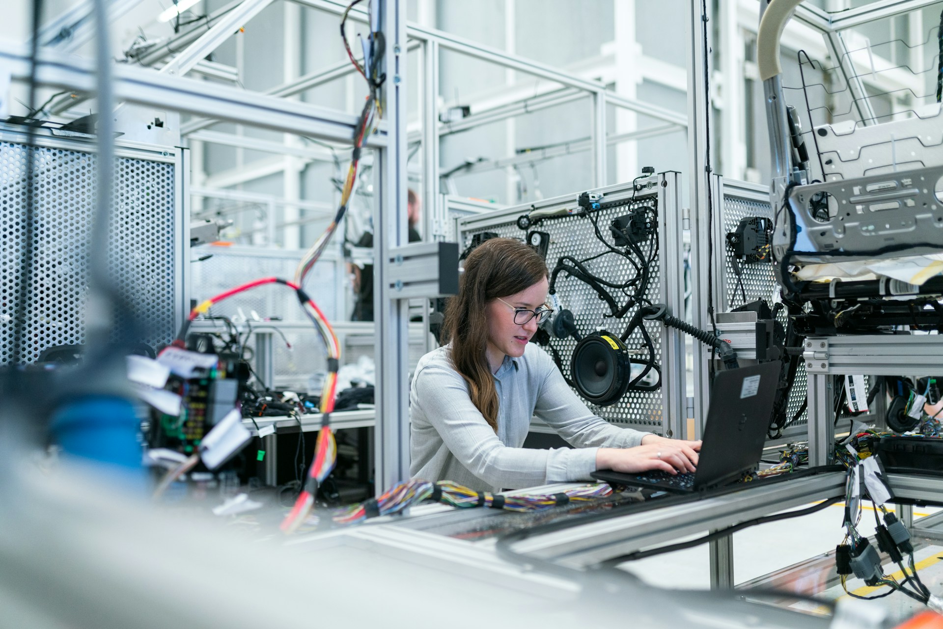 Woman Working on Laptop in Manufacturing Facility