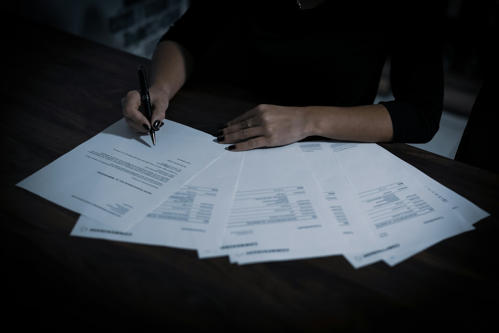 Person sitting at a table with multiple documents